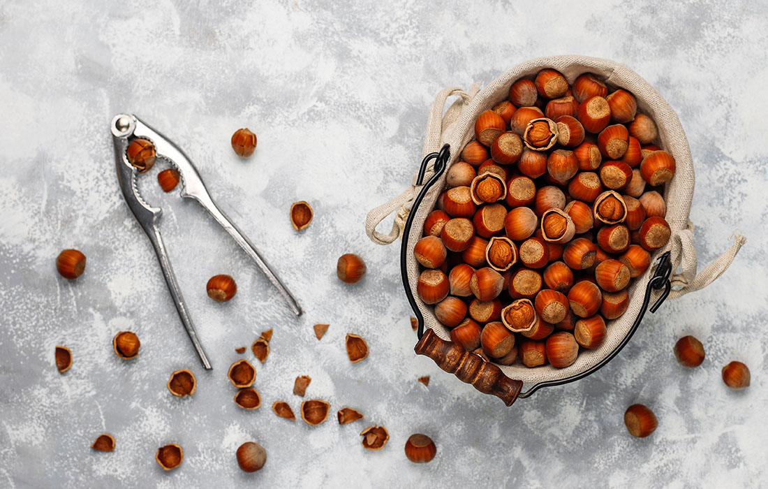 hazelnut-with-peeled-hazelnuts-small-plate-concrete-top-view